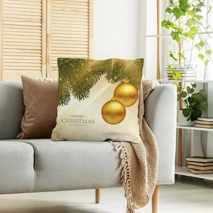 Federa per cuscino natalizio dorato con decorazioni su divano grigio in casa calda