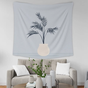 Detail of a blue tropical plant tapestry hanging above a modern living room sofa