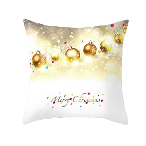 Dettaglio copricuscino natalizio con decori dorati e scritta Merry Christmas