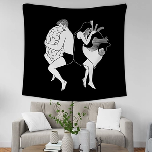 Close-up of minimalist black tapestry with brain and heart illustration over a sofa