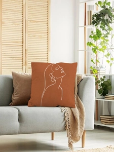 Close-up of terracotta linen cushion with minimalist white female face art on a sofa