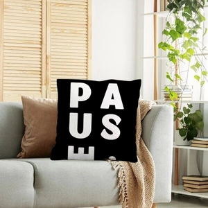 Modern minimalist black linen pillowcase featuring bold white PAUSE text on a sofa