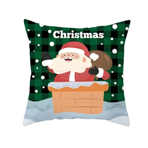 Detail of Christmas pillow cover with cartoon Santa Claus on green and black plaid fabric