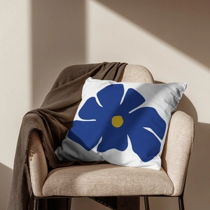 Housse de coussin à fleurs bleues sur une chaise avec un plaid en maille gaufrée