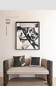 Detail view of abstract black and white art print in a sleek black frame over a sofa