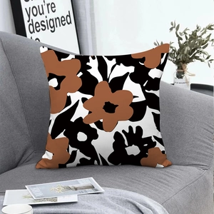 Modern Nordic abstract floral cushion cover in brown and black on a grey fabric sofa