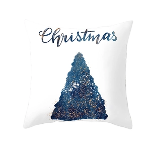 Close-up of blue ink watercolor Christmas tree and gold foil dots on white pillowcase