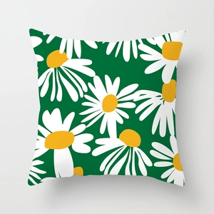 Close-up front view of a green decorative throw pillow cover with white daisy floral print