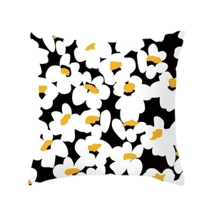 Square daisy throw pillow cover with white floral print on black background and yellow center