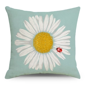 Close-up of linen cushion cover with white daisy print and ladybug on light blue base