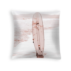 Detailed view of square peach skin pillowcase with Al Merrick surfboard print on sand