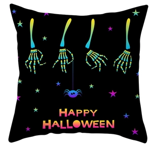 Detail of neon skeleton hands and Happy Halloween print on black cushion cover