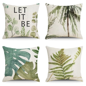 Detail of four tropical leaf pillow covers in cream linen with Nordic botanical prints