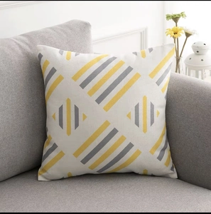 Fodera per cuscino geometrico moderno con strisce gialle e grigie su un divano grigio