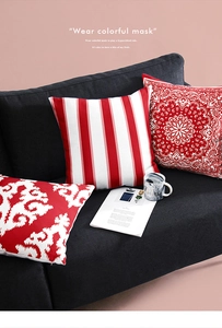 Detailed view of red and white patterned cushion covers on a sofa featuring geometric prints