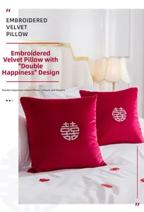 Détail de broderie Xi blanche sur coussins de mariage en velours rouge pour décoration
