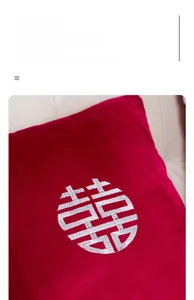 Gros plan détaillé de la broderie Xi blanche sur un coussin de mariage en velours rouge