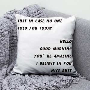 Detail of white peach skin cushion with black text print on a cozy grey sofa