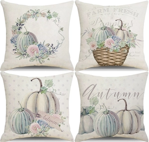 Close-up of four autumn pillow covers with pumpkin and floral prints on linen fabric