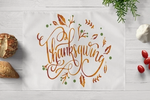 Detail of Thanksgiving table mat with maple leaves and berries on white linen texture