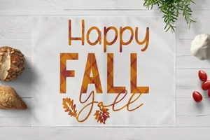 Flat lay of Thanksgiving placemat with Happy Fall y'all print on white wood background
