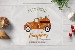 Macro detail of cotton linen placemat with autumn pumpkin farm truck and wooden texture