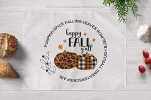 Detail of harvest table mat featuring pumpkin designs and Happy Fall seasonal text