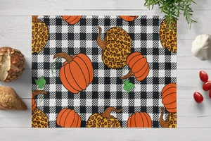 Detail of harvest pumpkin and leopard print on plaid heat resistant placemat