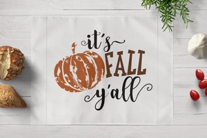 Detail view of cotton linen placemat with it's FALL y'all text and pumpkin prints