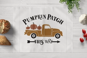 Detail of harvest table mat with pumpkin truck pattern on rustic wood background