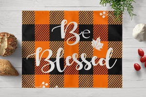 Close-up of harvest buffalo plaid placemat with Be Blessed maple leaf print