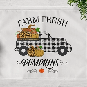 Harvest placemat with plaid truck and pumpkins on light wood grain background