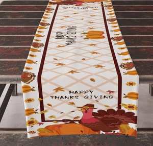 Detail of Happy Thanksgiving table runner with pumpkin and turkey prints on wooden table