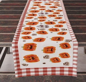 Detail of Happy Halloween table runner with pumpkins and autumn leaves on rustic wood table