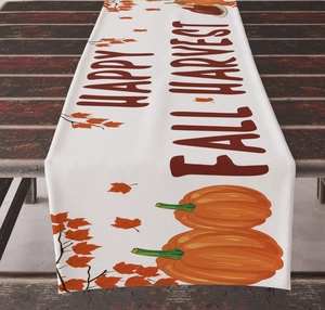Detail of Happy Fall Harvest table runner with pumpkin and maple leaf print on wood
