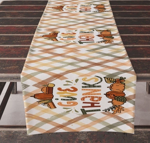 Detailed close-up of GIVE THANKS pumpkin and maple leaf print on plaid harvest table runner