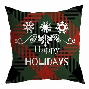 Dettaglio del tessuto scozzese rosso e verde con scritta bianca Happy Holidays sul cuscino