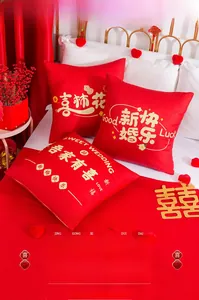 Close-up detail of Chinese wedding red velvet pillows with gold embroidery and zipper