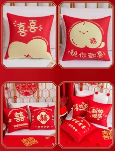 Detail of red Chinese wedding pillows with gold double happiness embroidery and slogans