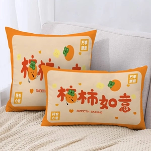 Detail of orange lumbar pillows with Persimmon illustrations on a grey sofa