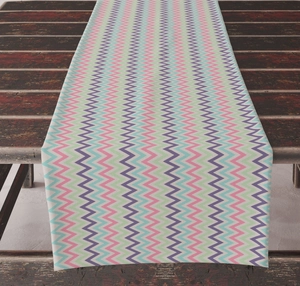 Detail of colorful chevron pattern table runner on a vintage dark wooden dining table