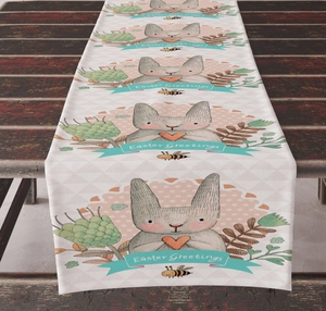 Close-up of Easter table runner with bunny illustrations on a dark vintage wooden table