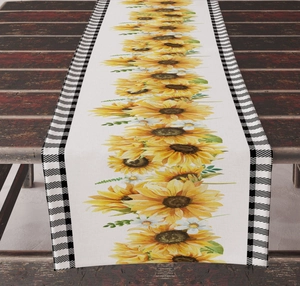 Detail of sunflower print table runner with black and white buffalo plaid edges on wood