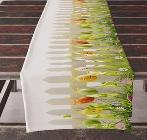 Close-up of Easter table runner with colorful eggs and bunny fence pattern on wood