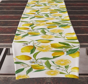 Close-up of linen table runner with fresh yellow lemon and floral pattern on wood