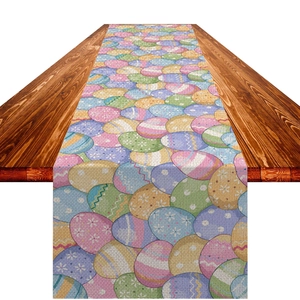 Macro shot of faux linen Easter table runner featuring colorful eggs on dark wood table