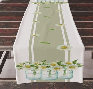 Close-up of linen table runner with daisy floral print on a rustic dark wood table