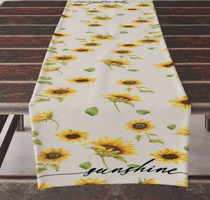 Detail of sunflower and lemon print table runner on dark wood texture surface