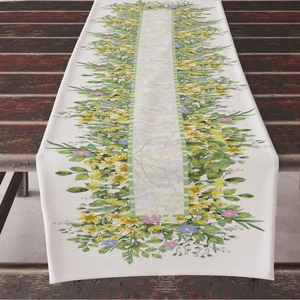 Linen table runner with floral print and green plaid trim on dark wood table