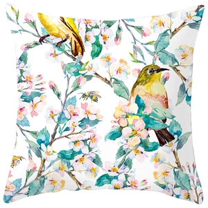 Detailed view of watercolor peach blossoms and yellow birds on a white square pillowcase